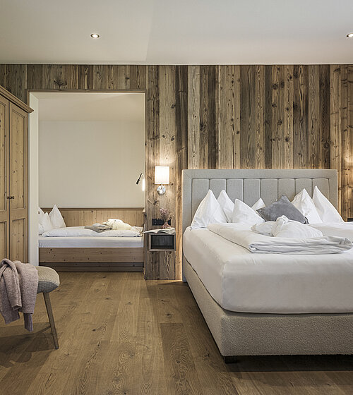 Gemütliches Hotelzimmer eingerichtet mit Holzboden, Holzmöbeln und natürlichen Materialien im Hotel Bachmanngut am Wolfgangsee
