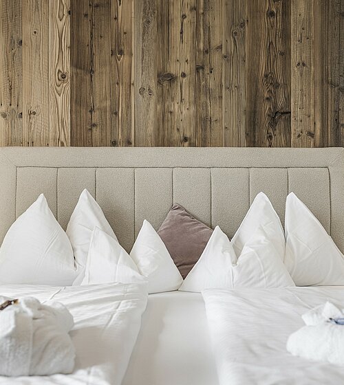 Gemütliches Hotelzimmer eingerichtet mit Holzboden, Holzmöbeln und natürlichen Materialien im Hotel Bachmanngut am Wolfgangsee