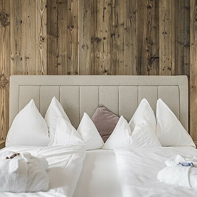 Gemütliches Hotelzimmer eingerichtet mit Holzboden, Holzmöbeln und natürlichen Materialien im Hotel Bachmanngut am Wolfgangsee
