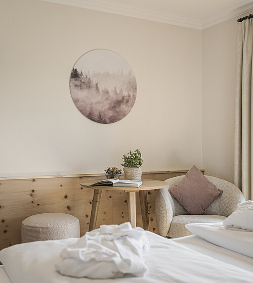 Gemütliches Hotelzimmer eingerichtet mit Holzboden, Holzmöbeln und natürlichen Materialien im Hotel Bachmanngut am Wolfgangsee