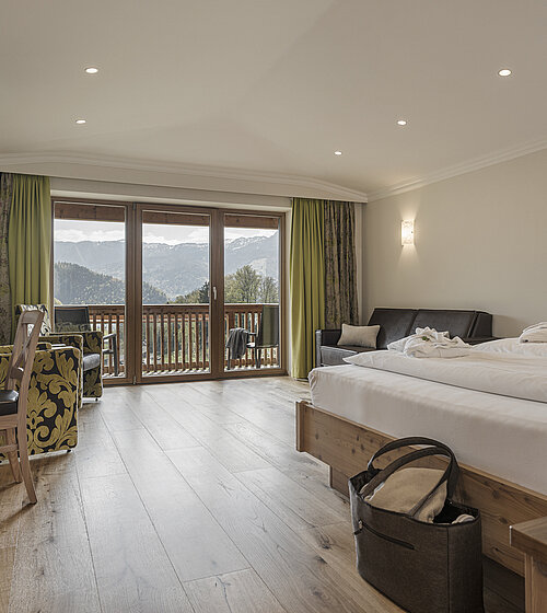 Gemütliches Hotelzimmer eingerichtet mit Holzboden, Holzmöbeln und natürlichen Materialien im Hotel Bachmanngut am Wolfgangsee