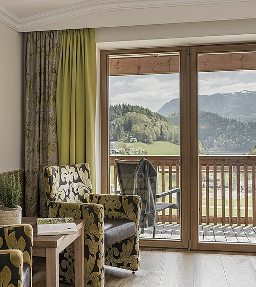 Gemütliches Hotelzimmer eingerichtet mit Holzboden, Holzmöbeln und natürlichen Materialien im Hotel Bachmanngut am Wolfgangsee